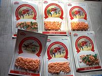 Six unopened Pola HO scale model railroad figure and animal packages arranged on a white surface, showing product labels and plastic compartments with unpainted figures inside.