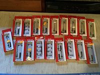 Overhead view of 18 assorted HO street lamps, all in original packaging, arranged on a flat surface.