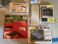 Photo shows various sealed model train accessory kits and Britains animal figures in packages: signal bridge, roof and trim kit, retaining walls, garage kit, and animal figures.