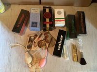 Photo showing multiple perfume boxes and vintage perfume atomizer bottles on floor, including La Bottega and velvet pouches with vials