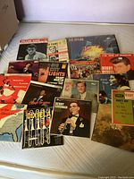 Photo of lot showing multiple vinyl records with visible covers including Def Leppard, Bobby Rydell, Joe 'Fingers' Carr, Patti Page, and others.