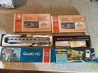 Photo showing all items in the lot including the two train cars and two boxes of electrical transformers.