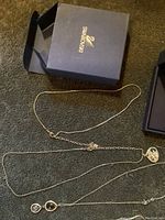 Lot includes two sterling silver Swarovski necklaces displayed with an original blue Swarovski box with gold logo.