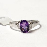 Front view of the 10K white gold ring with central oval amethyst and side diamonds showing detail and gemstone color.