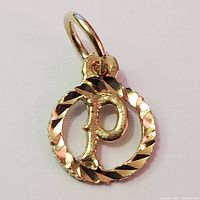 Close-up front view of 10K yellow gold pendant featuring letter 'P' in a detailed circular frame.