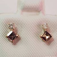 Front view of earrings showing square-cut pink tourmaline and round diamond set in yellow gold.