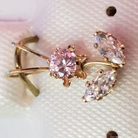 Close-up front angle of the pendant showing the pink and clear cubic zirconia stones in a 14K yellow gold setting.