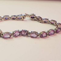 Close-up side view of the silver amethyst bracelet showing detailed stone settings and clasp.