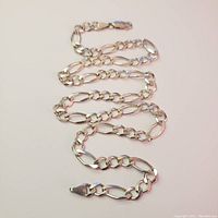 Full view of silver men's necklace laid out showing length and chain links