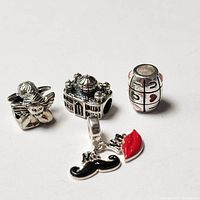 Four silver Pandora style beads including an angel, mosque, tic tac toe bead, and Mr & Mrs charm.