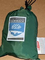 Green Equip branded one person hammock packed inside green drawstring bag with label showing hammock illustration.