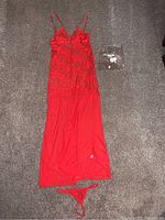 Full view of the XL red lingerie slip dress laid flat on carpet with matching G string above bottom