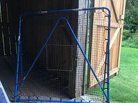 Front view of the EZ Goal rebounder showing the blue coated metal frame, black net with center square target, and support triangle stand.