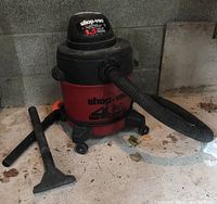 Shop-Vac 4 Gallon Wet/Dry Vacuum with hose and wand attachments on concrete floor.