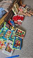 Photo showing various boxes of vintage glass Christmas ball ornaments in colors red, green, gold, blue, some labeled 'Santa Lady' and 'Christmas Tree Ornaments'.