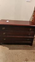 Front view of Lane cedar lined chest showing three drawers with brass oval drop handles and bracket feet.