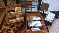 Photo shows multiple boxes filled with assorted music cassette tapes of various genres and artists.