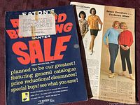 Cover page of 1964 Eaton's Winter Sale catalog featuring large red and blue text with a note and partial view of inside fashion pages.