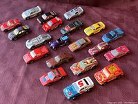 Photo showing 20 vintage die-cast cars arranged on table surface, variety of models and colors