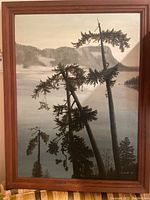 Front view of the framed landscape painting showing tall trees and a mountainous lake scene.