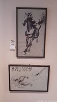Photo of two framed oriental silk artworks hung on a wall, one of a horse and one of a musical instrument with calligraphy.