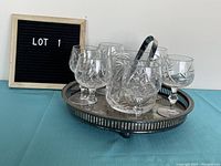 Photo showing ice bucket with six snifter glasses and metal tongs on a silverplate tray
