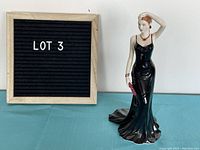Front view of the Royal Doulton Chloe figurine next to a lot number board showing the size and condition.