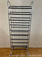 Front view of the tall metal shoe rack showing multiple black horizontal bars and a silver frame.