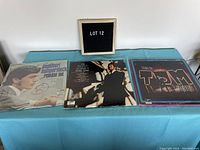 Three vinyl albums displayed on a blue cloth. Left to right: Engelbert Humperdinck's "Release Me", Tom Jones' "Tom Jones in Person", and Tom Jones' "This Is Tom Jones". Albums show visible wear.