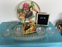 Photo showing the round toucan serving tray with four clear glass bowls, square toucan dish, and rectangular clear acrylic tray on a blue surface.