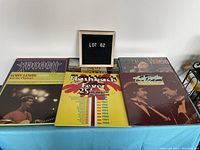 Six vinyl albums arranged on a blue tablecloth showing the covers of artists including Bobby Vinton, Gerry Lewis and the Playboys, and a Flashback Fever compilation.