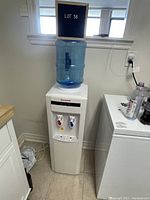 Front full view of the Honeywell water dispenser with blue water jug on top and two spigots visible, one with red lever (hot) and one with blue lever (cold).