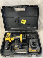 Open black carrying case containing the cordless drill driver, two batteries, and charger