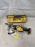DeWALT multi tool with box, user manual, and accessories laid out, showing the lot contents.