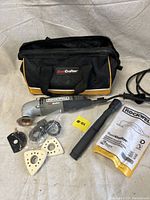 Rockwell Sonicrafter oscillating tool with attachments, carrying bag, and user manual on fabric background.