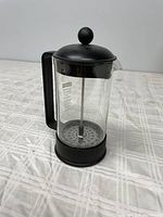 Front view of the Bodum French press coffee maker showing the clear glass carafe with black plastic handle and lid with knob.