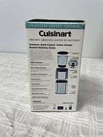 Side view of the Cuisinart Grind Central Coffee Grinder box describing features like high-tech housing, one-touch operation, capacity for 18 cups, and stainless steel design.