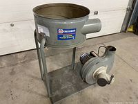 Front side view of King Canada dust collector motor unit showing cylindrical dust collection housing mounted on metal frame and attached motor.