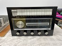 Front view of Electrohome stereo console front panel with radio tuner, five control knobs, and multiple selector buttons.