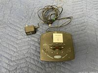 Top view of GE answering machine showing control buttons and power adapter attached by cable.