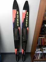 Top view of two O'Brien Performer Kevlar waterskis showing colorful branding and levered-slide adjustable bindings.