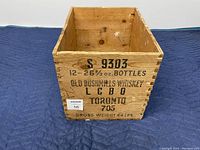 Front of wooden box showing printed text detailing bottle count and branding.