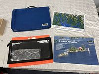 Full view of the items including carrying case, map, clear sleeve folder, and the chartbook cover