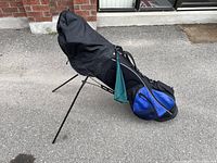 Full side view of black and blue Wilson golf stand bag with clubs covered
