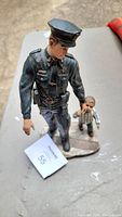 Top view of the police officer and child statue made of resin showing details of the figures and base.
