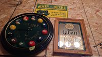 Photo showing the front of the billiard-themed clock and the John Deere and Labatt signs on the floor underneath.