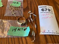 All three items laid out on wood surface with green labels and sale card showing karat markings