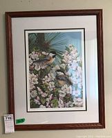 Framed print featuring two chickadees among blossoms in a reddish wood frame with white matting