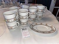 12 stacked Royal Doulton mugs with floral and geometric band pattern and one matching oval under plate.