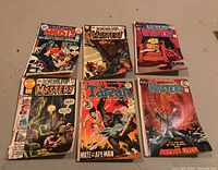 Top view showing six comic books including Vault of Evil, multiple Do You Dare Enter the House of Mystery issues, Tarzan, and Ghosts.